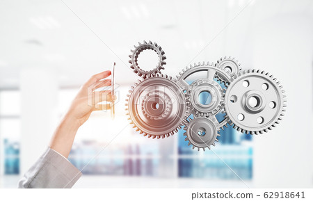 Engine mechanism in male hands as symbol for cooperation or team Engine mechanism in male hands as symbol for cooperation or team 62918641
