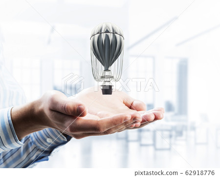 Concept of travel and imagination with aerostat in male palms. M 62918776