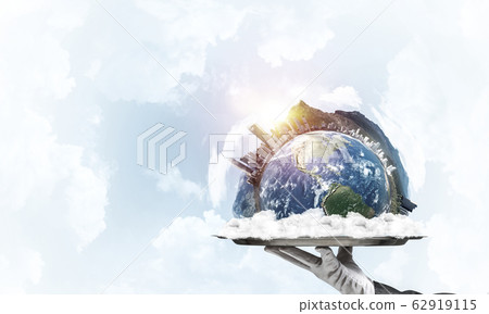 Hand of waitress presenting Earth globe on tray. 62919115