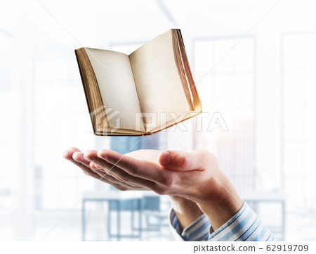 Education or writing concept with old book in male palms. Mixed 62919709