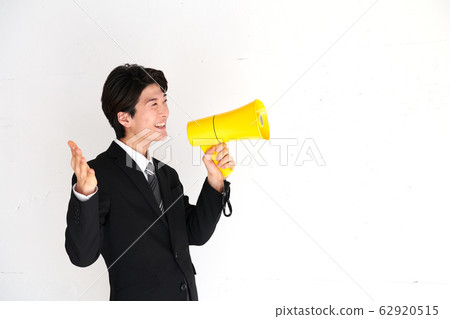 Businessman announcing with a yellow megaphone Businessman announcing with a yellow megaphone 62920515