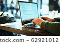 closeup mans hands freelancer sitting in cafe working laptop 62921012
