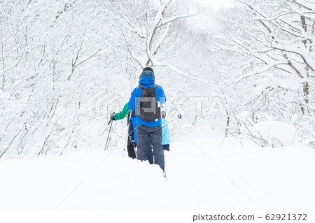 Parents and children enjoying snowshoes 62921372
