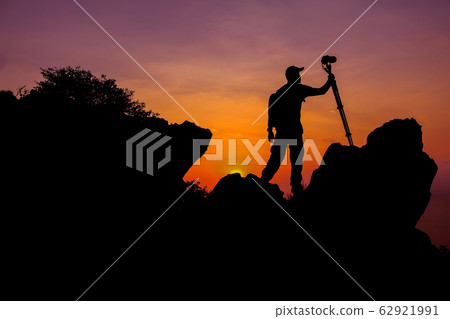 Photographer climbing on the top of the mountain Photographer climbing on the top of the mountain 62921991