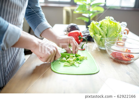 Male hands slicing lettuce on a cutting board. Male hands slicing lettuce on a cutting board. 62922166