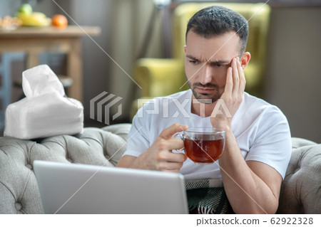 Dark-haired young man suffering from the headache 62922328