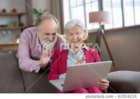 Elderly married couple feeling happy while having video call 62924228