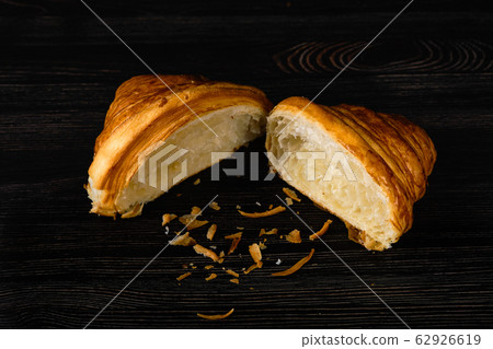 Fresh golden croissant on black table 62926619