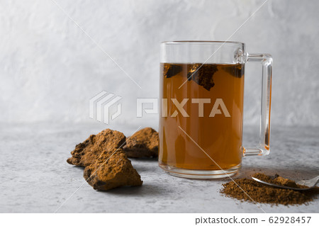 Chaga tea in glass cup. Trendy healthy infusion. 62928457