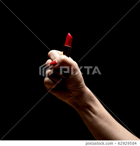 Women's hand hold a red lipstick 62929584