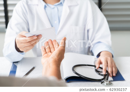 Doctor writing diagnosis and giving a medical prescription to senior women Patient 62930237
