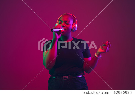 African-american young woman's portrait on purple pink background African-american young woman's portrait on purple pink background 62930956