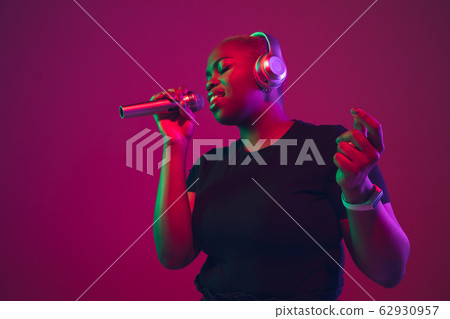 African-american young woman's portrait on purple pink background African-american young woman's portrait on purple pink background 62930957