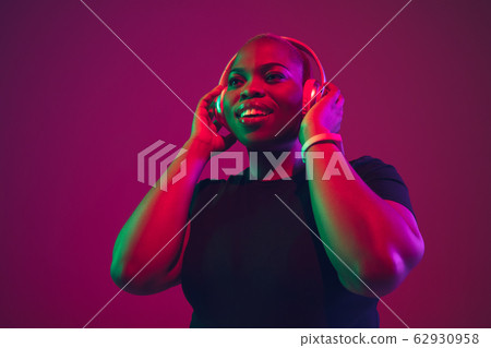 African-american young woman's portrait on purple pink background African-american young woman's portrait on purple pink background 62930958