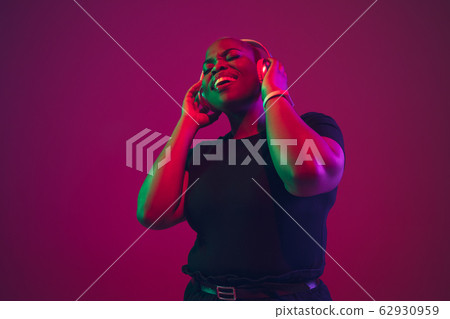 African-american young woman's portrait on purple pink background African-american young woman's portrait on purple pink background 62930959