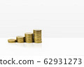 Growing stacked of coins on white table. 62931273