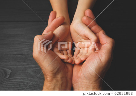 Hands of elderly man holding hand of younger man Hands of elderly man holding hand of younger man 62931998