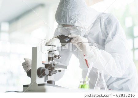 Medical scientist analyzing microscope slides in research lab for 2019-nCoV vaccine  62933210