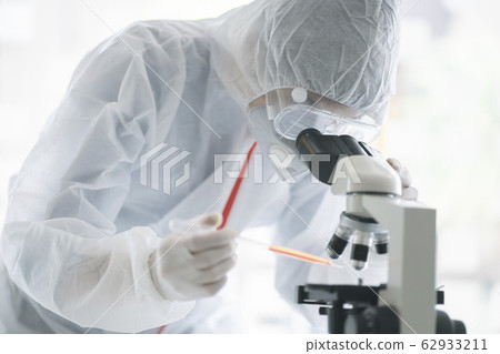 Medical scientist analyzing microscope slides in research lab for 2019-nCoV vaccine  62933211