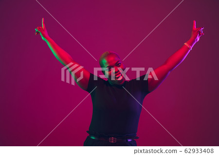 African-american young woman's portrait on purple pink background African-american young woman's portrait on purple pink background 62933408