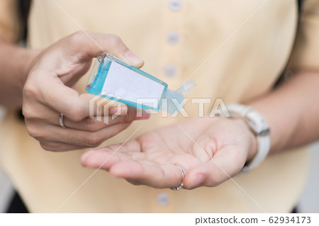Woman hands using wash hand sanitizer gel 62934173
