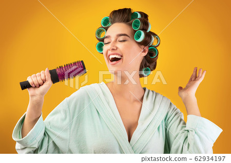 Housewife Holding Hair Brush Singing Having Fun Posing In Studio Housewife Holding Hair Brush Singing Having Fun Posing In Studio 62934197