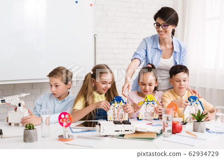 Robotics class at school. Kids creating robots with teacher 62934729