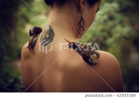 Beauty portrait on young stylish woman with snails Beauty portrait on young stylish woman with snails 62935580