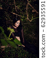 beautiful brunette girl in a dark fairy forest 62935591