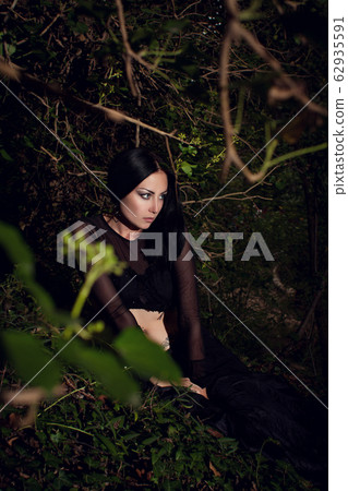 beautiful brunette girl in a dark fairy forest beautiful brunette girl in a dark fairy forest 62935591
