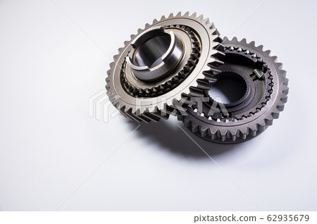 New parts on a gray background. Gears of gear shifting torque transmission. Conceptually mechanical background. Shiny gear box gear teeth 62935679