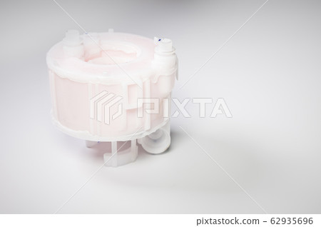 New spare part. Replaceable white plastic inner fuel filter on a gray gradient background 62935696