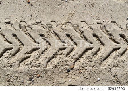 offroad tire track on sandy beach 62936590
