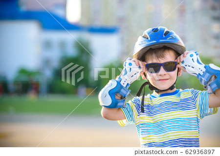 Little boy riding on rollers in the summer in the Little boy riding on rollers in the summer in the 62936897