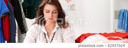 Experienced tailor working on making vintage dress 62937024