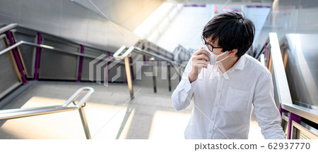 Asian man wearing mask at skytrain station Asian man wearing mask at skytrain station 62937770