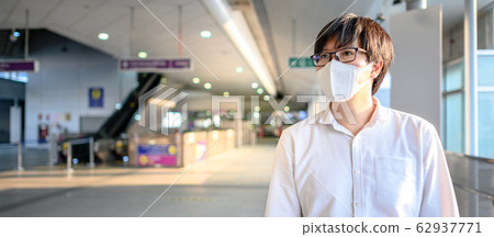 Asian man wearing mask at skytrain station Asian man wearing mask at skytrain station 62937771