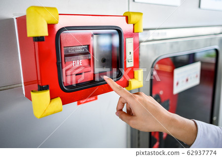 Male hand pointing at red fire alarm switch Male hand pointing at red fire alarm switch 62937774