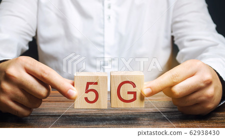 A man holds wooden blocks with the word 5G. High-speed mobile Internet. New generation networks. Fifth generation cellular network technology 62938430