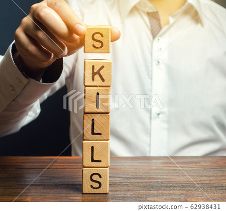 A man puts wooden blocks with the word Skills. Knowledge and skill. Self improvement. Education concept. Training. Leadership skills. Human abilities 62938431