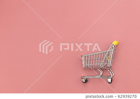 Metal shopping cart on pink background. Metal shopping cart on pink background. 62939270