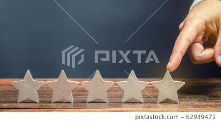 Critic puts the fifth star. The concept of the rating of hotels and restaurants. The evaluation of visitors. Quality level, good service. Best customer rating. Feedback. Satisfaction Critic puts the fifth star. The concept of the rating of hotels and restaurants. The evaluation of visitors. Quality level, good service. Best customer rating. Feedback. Satisfaction 62939471