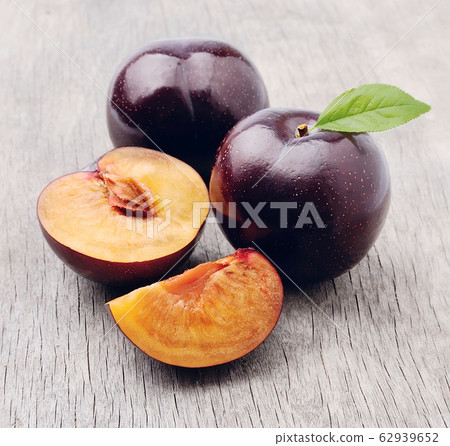 Fresh plums on wooden backgrounds. 62939652