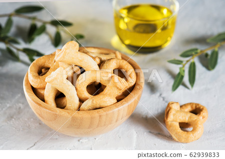 Taralli is a traditional Italian snack food typical of Puglia regional cuisine in wooden bowl. Ingredients: flour, white wine and olive oil. 62939833
