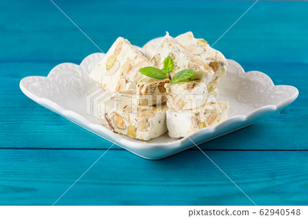 Italian torrone or nougat with almonds and pistachios from Apulia, traditional christmas sweets. 62940548