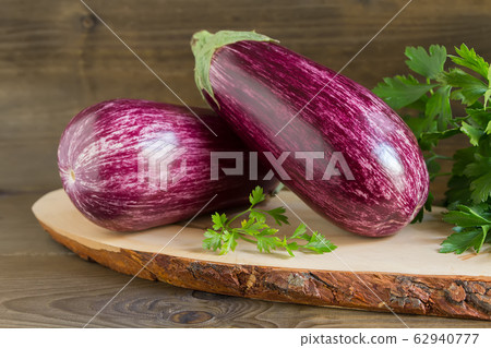 Organic fresh eggplants on dark wooden background Organic fresh eggplants on dark wooden background 62940777