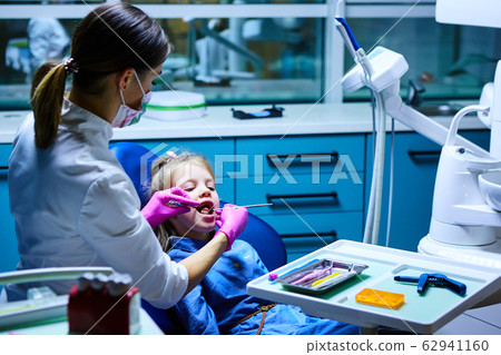 Young female dentist working in her office. Young female dentist working in her office. 62941160