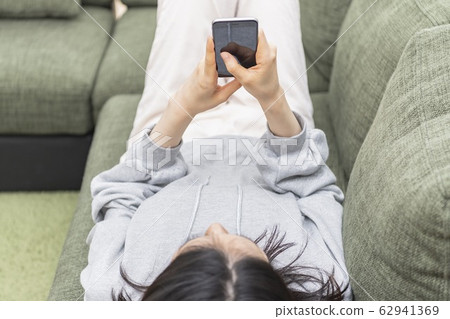 A lady who sleeps and operates a smartphone A lady who sleeps and operates a smartphone 62941369