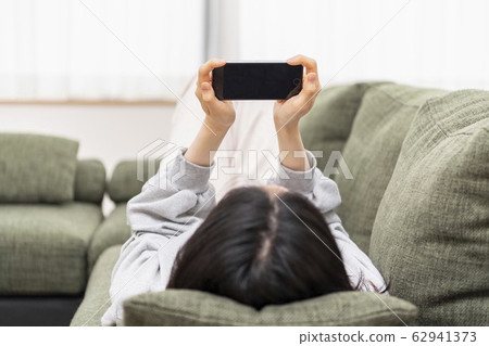 A lady who sleeps and operates a smartphone A lady who sleeps and operates a smartphone 62941373