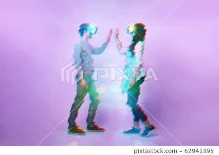 Couple in love communicate using a virtual reality headset. Image with glitch effect. Couple in love communicate using a virtual reality headset. Image with glitch effect. 62941395
